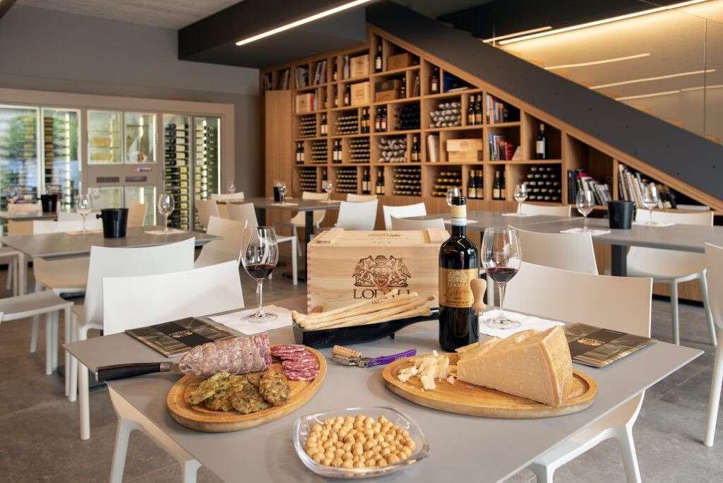 Gedeckter Tisch mit Käse, Nüssen und Rotwein in der Vinothek von Walter Lodali